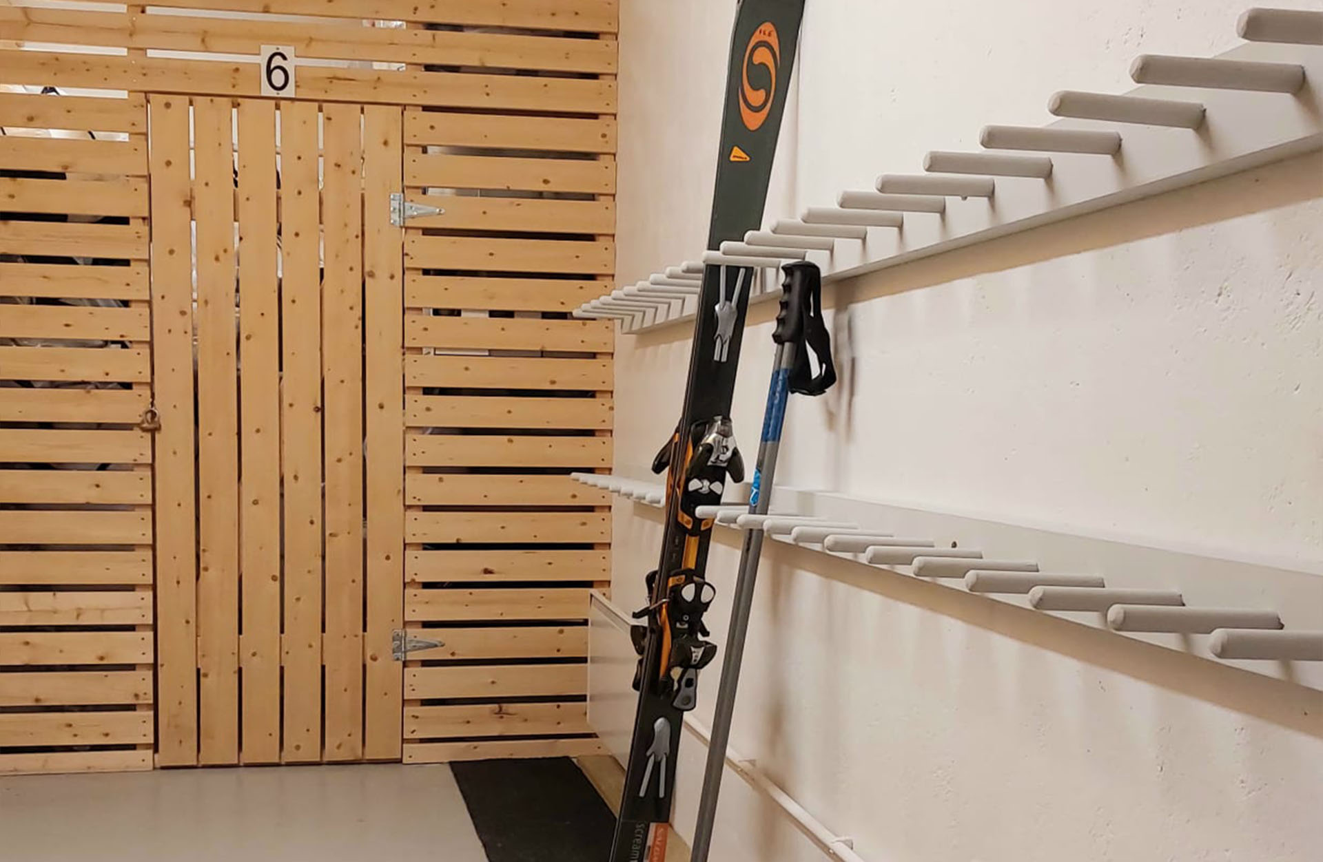 Suksien säilytystila kellarissa. Shared ski storage room in the basement.